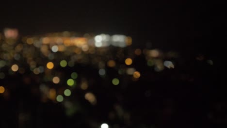 Scenic-wide-shot-panning-over-city-lights-and-fireworks-bokeh-rack-focus