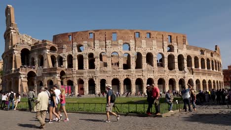 Revealing-wide-shot-of-the-Colosseum-of-Rome-with-tourists-walking-and-taking-selfie-pictures