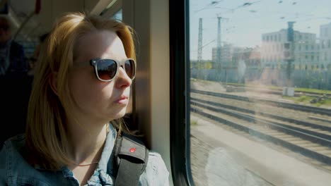 Frau-Mit-Sonnenbrille-Fährt-Im-Sommer-Mit-Dem-Zug