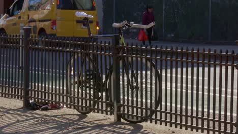 Bicycle-parked-next-to-fence-on-the-street
