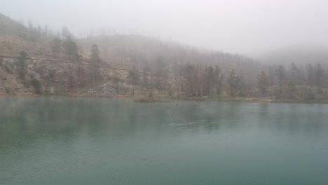 four-ducks-landing-on-a-lake-between-mist