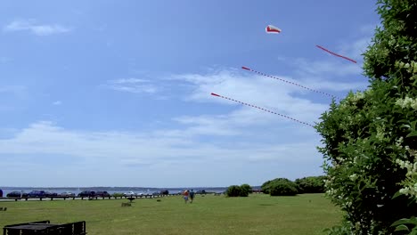 A-couple-walks-under-kites-being-flown-at-the-ocean-front