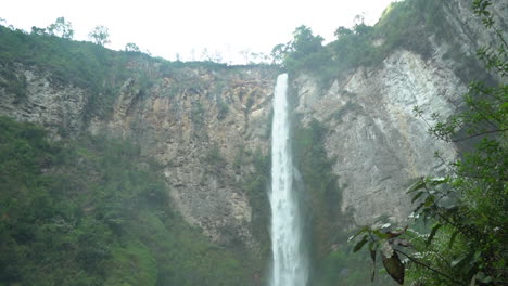 Schwenken-Sie-Vom-Grund-Der-Schlucht-Nach-Oben,-Um-Eine-Kleine-Brücke-Und-Den-Riesigen-Wasserfall-Sipso-Piso-In-Nord-Sumatra,-Indonesien,-Zu-Enthüllen