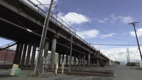Rollende-Ansicht-Der-11.-Brücke-Im-Hafen-Von-Tacoma,-Washington,-Teilweise-Bewölkt,-Grünes-Gras,-Betonsäulen