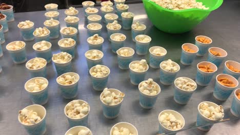 Popular-kids-snack-items-like-pretzels,-popcorn,-and-gold-fish-placed-into-little-cups-for-kids-to-grab-and-go-easily
