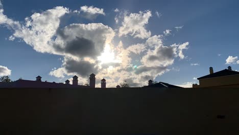 time-lapse-of-rooftops-with-the-sun-behind-clouds