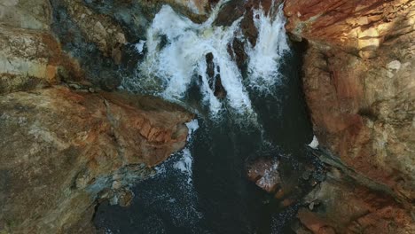 Aerial-view-of-foaming-water-between-rocks
