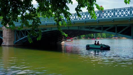 Városligeti-Lake-City-park,-paddling-boats-under-the-bridge,-continue-shot