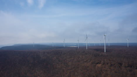 Aerial-drone-hyperlapse-of-mountain-wind-turbines-spinning-in-the-wind-and-clouds