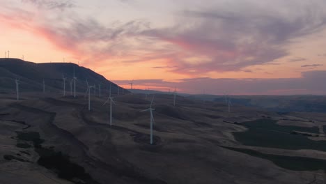 Aerial-Landscape-View-of-Wind-Turbines-on-a-Windy-Hill-during-a-colorful-sunrise