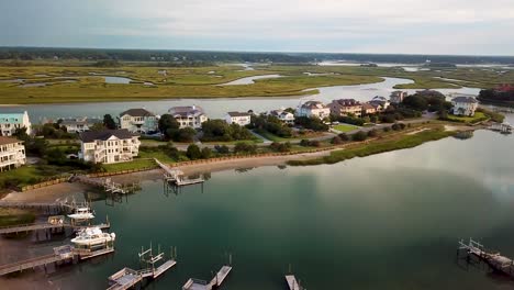 Early-morning-sunrise-drone-flyover-to-the-left-over-piers-and-houses-at-figure-eight-island-inner-harbor-in-Wilmington-North-Carolina