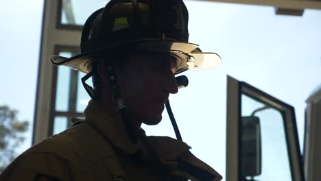 Der-Feuerwehrmann-Setzt-Einen-Schützenden-Feuerwehrhelm-Und-Eine-Ausrüstung-Auf,-Während-Er-Sich-Darauf-Vorbereitet,-Auf-Einen-Notfall-Zu-Reagieren