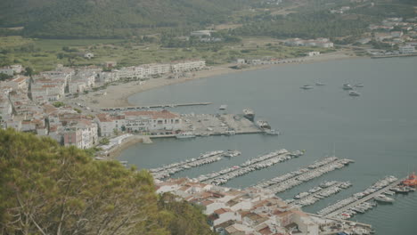 Close-up-view-on-El-Port-de-la-Selva-harbour-from-a-mountain-top-with-a-boat-coming-in