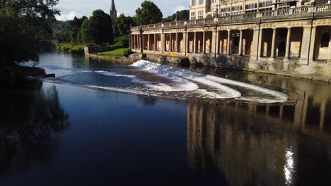 Pulteney-Weir-and-the-Empire-Hotel-in-Bath,-Somerset-on-a-Beautiful-Summer’s-Morning-fading-out-to-the-River-Avon