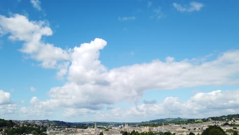 Aufnahme-Der-Skyline-Der-Stadt-Bath-Vom-Aussichtspunkt-Am-Hang-An-Einem-Sonnigen-Sommertag,-Der-Vom-Blauen-Himmel-Mit-Weißen,-Flauschigen-Wolken-Einblendet