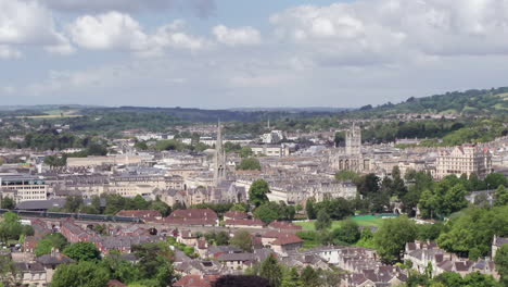 Aerial-Shot-Pulling-Away-from-the-City-of-Bath,-including-Bath-Abbey---GWR-Train,-in-the-South-West-of-England-on-a-Sunny-Summer’s-Day-with-Narrow-Crop