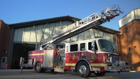 Fire-engine-sits-shiny-outside-of-a-fire-station-in-the-early-morning-sunlight