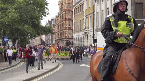 Police-horses-guide-Antifa-as-they-protest-Tommy-Robinson-in-London,-UK