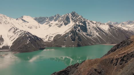 Ascending-shot-over-reservoir-in-the-Andes-mountains-showing-reflection-on-the-water-4K
