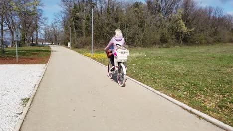 Madre-En-Bicicleta-Con-Su-Hija-En-Un-Asiento-Para-Niños-En-El-Carril-Bici