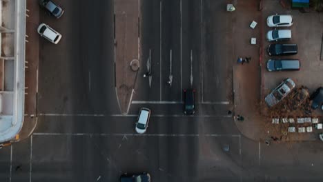 A-Tracking-Drone-Shot-of-a-Black-Car-Entering-a-City-Road-Intersection-at-dusk
