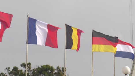 Bunte-Europäische-Flaggen,-Die-An-Windigen-Tagen-Am-Jachthafen-Fliegen