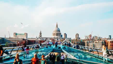 London-England,-circa-:-timelapse-People-walking-over-Millennium-bridge-with-St-Pauls-cathedral-background