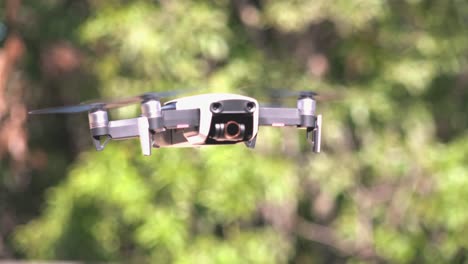 Nahaufnahme-Einer-Drohne,-Die-Mit-Bäumen-Im-Hintergrund-Fliegt