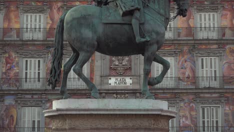 Zoom-in-to-sign-at-Plaza-Mayor-in-Madrid-Spain-in-between-legs-of-King-Philip-III-statue