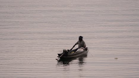 Pescador-Perfilando-Mientras-Lanza-Y-Saca-Su-Red-En-El-Río-Antes-Del-Anochecer,-En-Cámara-Lenta