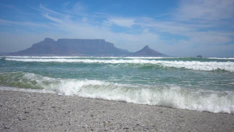 Stetige-Zeitlupe-Des-Atlantiks-Mit-Wellen-Und-Dem-Tafelberg-Im-Hintergrund