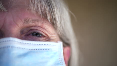 Nahaufnahme-Von-Gesicht-Und-Auge-Einer-Alten-Frau-Mit-Einer-Medizinischen-Patientenmaske,-Um-Die-Ausbreitung-Einer-Ansteckenden-Krankheit-Zu-Verhindern
