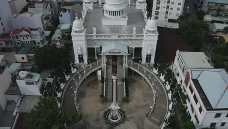 Aerial-shot-of-big-white-neoclassical-church-building-with-circular-driveway,-a-central-dome-and-four-small-domes
