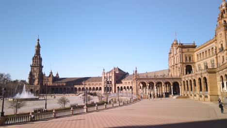 Plaza-de-Espana-in-Seville,-Spain,-Pan-left-from-building-to-fountain-and-tower