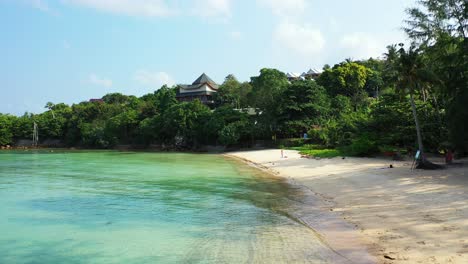 Ruhiger-Exotischer-Strand-Mit-Weißem-Sand,-Der-Von-Ruhigem,-Klarem-Wasser-Der-Türkisfarbenen-Lagune-Vor-Dem-Luxuriösen-Resort-In-Ko-Pha-Ngan,-Thailand,-Umspült-Wird