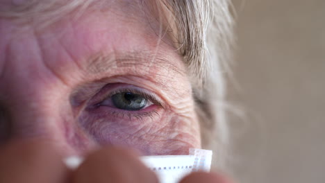 Close-up-of-an-elderly-wrinkled-face-putting-on-a-medical-patient-mask-to-prevent-spreading-a-contagious-disease-or-getting-sick