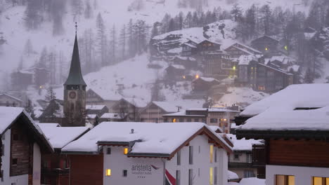 Snow-covered-church,-hotels-and-homes-in-Zermatt,-Switzerland