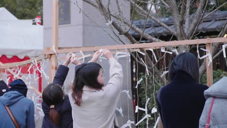 Local-citizens-hanging-New-Years-resolution-notes-on-rope-at-Yasaka-Shrine