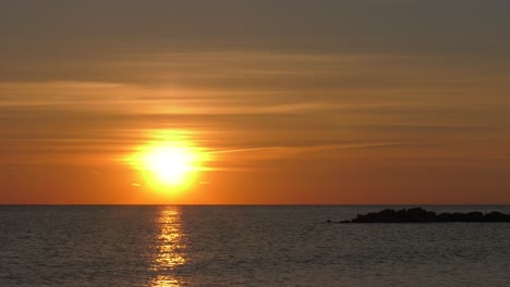 Hazy-orange-sunrise-time-lapse-over-calm-Mediterranean-Sea,-coast-of-Spain