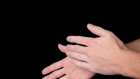 Eine-Person,-Die-Ihre-Hände-Mit-Kreidepulver-Reibt-Und-Abstaubt,-Isoliert-Auf-Schwarzem-Hintergrund