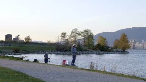 Friends-Went-Fishing-On-A-Weekend-In-A-Lake-Vancouver-With-A-View-Of-Mountains-And-Tall-Buildings-Before-Sunset---Wide-Shot