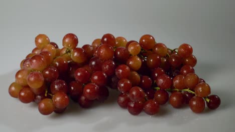 A-bunch-of-red-seedless-grapes-on-a-white-surface