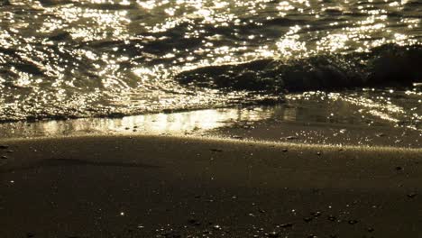 Slow-motion-waves-on-sand-at-dawn,-close-up-abstract