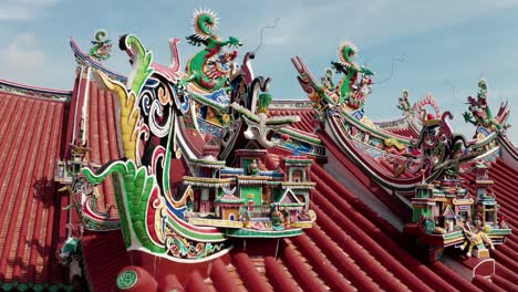 Ancestral-clan-homes-and-Chinese-dragon-sculptures-adorn-the-roof-of-the-Yeoh-Kongsi-Temple,-Aerial-orbit-around-reveal-shot