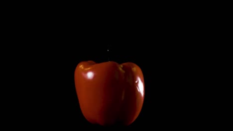 An-isolated-big-red-pepper-spinning-against-a-black-background