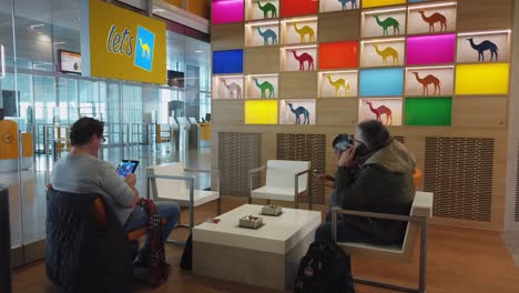 Travellers-relax-in-Camel-Smoking-Lounge-at-terminal-between-flights