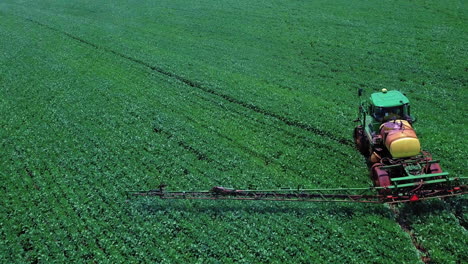 Tractor-spraying-plantation-with-pesticides,-they-cause-serious-damage-to-health,-including-cancer