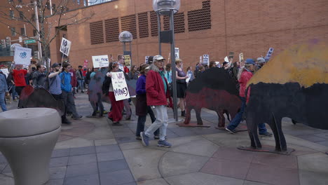 Anti-war-protesters,-holding-homemade-signs,-march-through-Downtown-Denver-Colorado