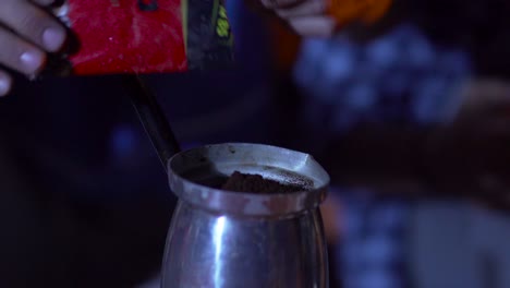 Close-up-pours-coffee-into-the-pot,-And-then-mix-the-coffee-with-a-plastic-spoon