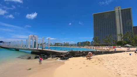 Niña-Con-Flotadores-Caminando-En-Suaves-Olas-En-La-Playa-En-Waikiki,-Hawaii,-Cámara-Lenta